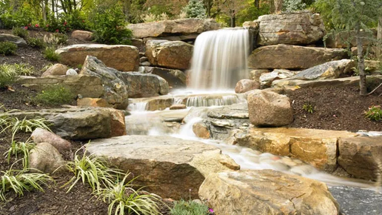 A beautiful rock waterfall professionally installed by our skilled employees at a home in West Des Moines, IA.