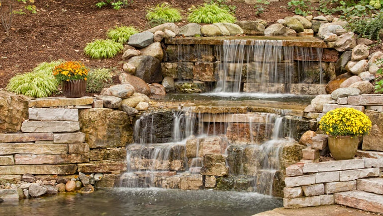 Stacked stone hardscape waterfall for homeowner in Des Moines, IA.