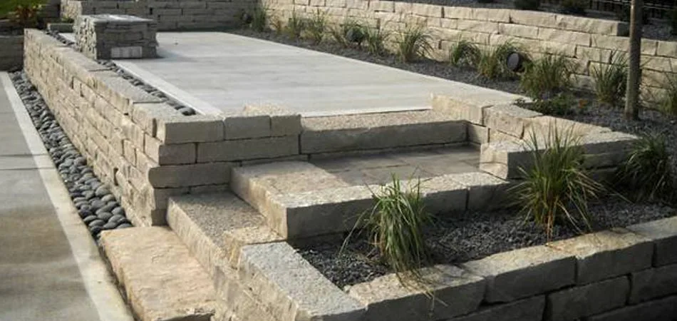 A recently constructed retaining wall with planters and rock surround at a home in Clive, Iowa.