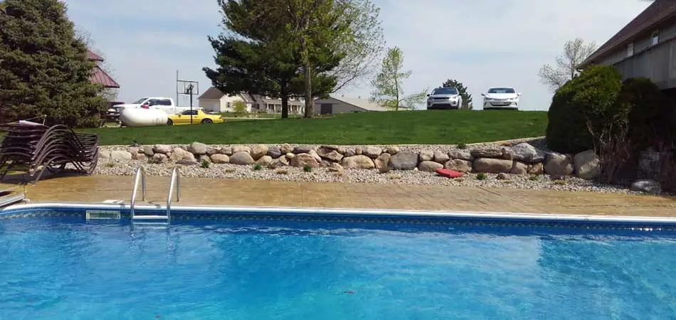 This stonewall was built for a Des Moines homeowner, as a natural looking accent for the pool in the foregrounde.