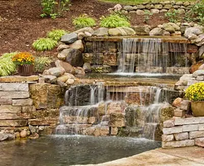 Custom stone waterfall and pond installation in West Des Moines, IA.