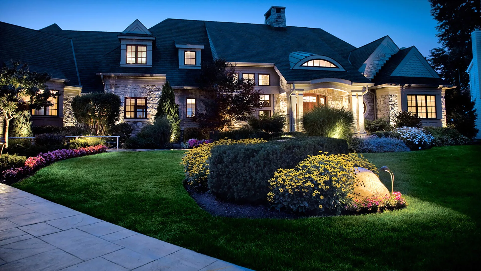 A home with outdoor lighting and landscaping in Adel, IA.