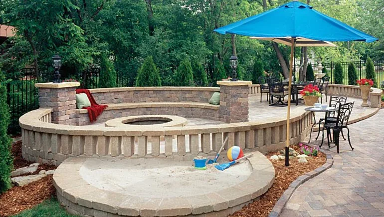 Custom built patio, seating wall, fire pit and landscaping at a home in Polk City, Iowa.