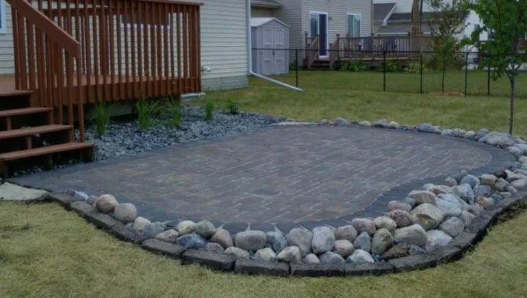 Hardscape paver patio with rock border at a home in Waukee, Iowa.