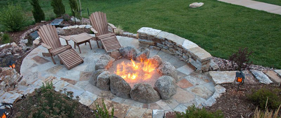 Stone patio and fire pit with chairs in Adel, Iowa.