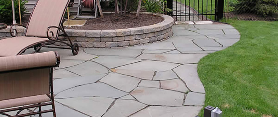 Slate stone patio with retaining wall and chairs in Altoona, Iowa.