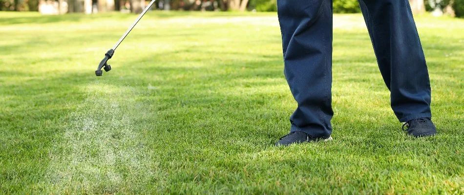 Crew fertilizing a green lawn in Des Moines, IA.