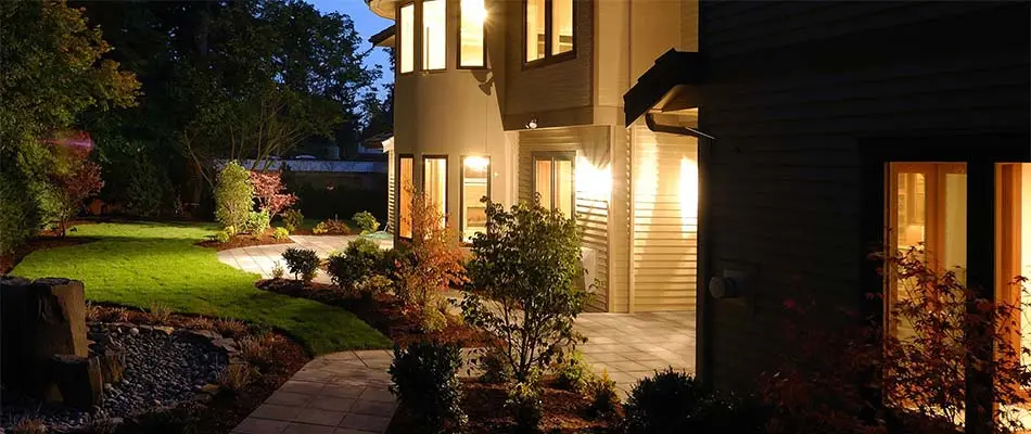 Home in Waukee, IA with oandscape lighting installed along walkway and around doorways.