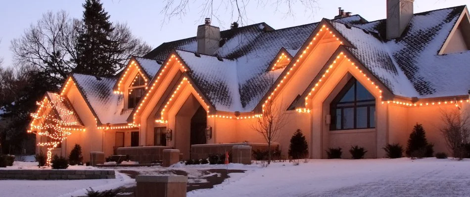 Warm white holiday lighting along the roof of a house in Des Moines, IA.