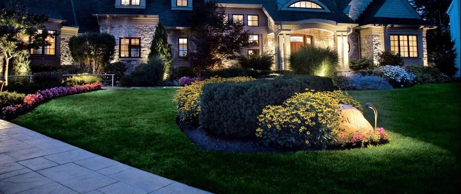 A residential landscape design in Des Moines, IA, at night with landscape beds. 