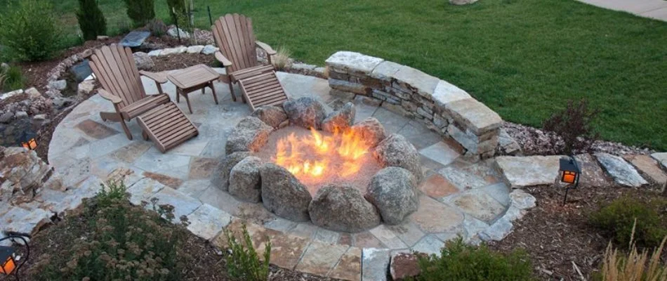 Natural boulder fire pit on a patio in Des Moines, IA.