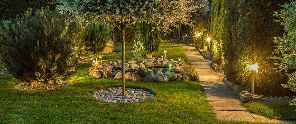 Landscape lighting illuminating a walkway outside a home in Des Moines, IA.