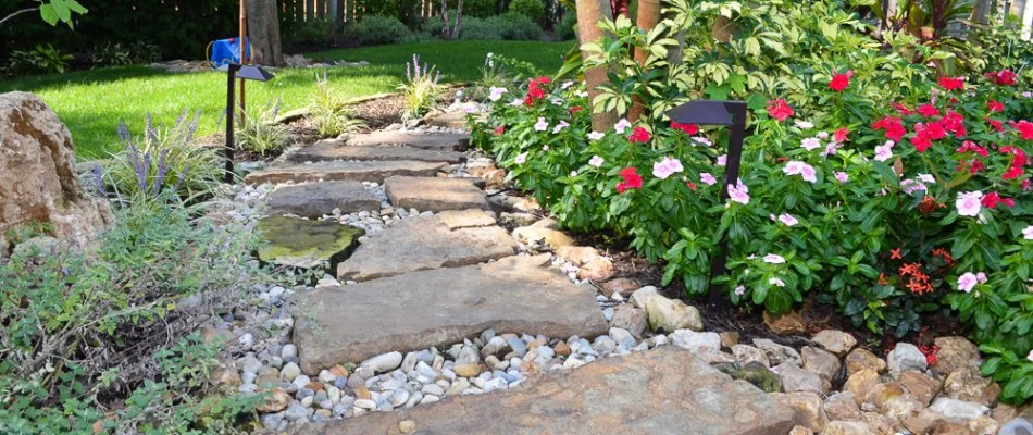 Colorful flowers, plants, and outdoor lighting along a pathway in Des Moines, IA.