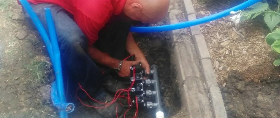 A professional in Des Moines, IA, repairing an irrigation system valve.