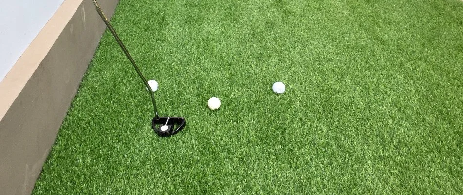 Putter and golf balls on putting green in Des Moines, IA.