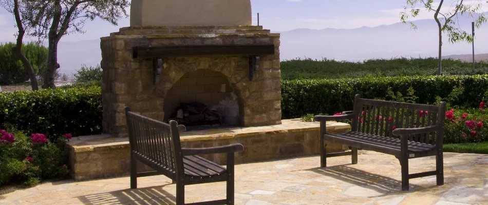 Shrubs behind an outdoor fireplace in Des Moines, IA.