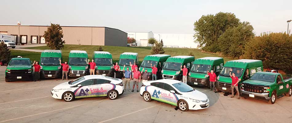 A+ Lawn & Landscape team and fleet of work trucks in Des Moines, IA.