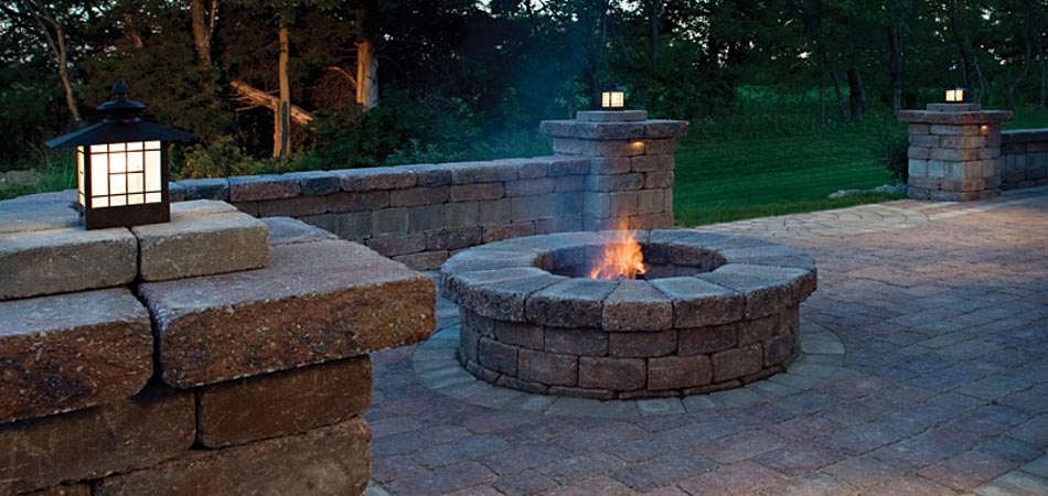 Custom hardscape element that includes a new fire pit, patio, and seating wall at a home in Polk City, IA.