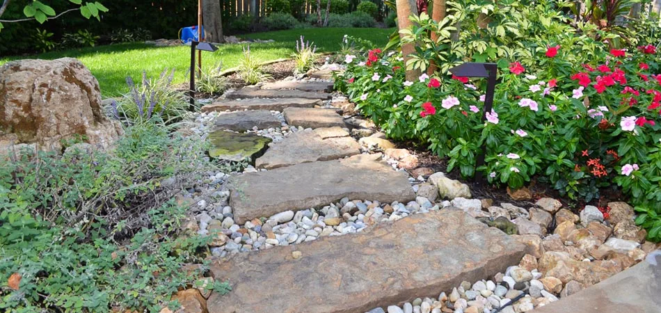 Recently installed hardscape pathway and new landscaping at a residential property in Urbandale, IA.