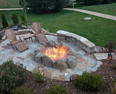 Custom flagstone seating wall and fire pit patio in Des Moines, IA.