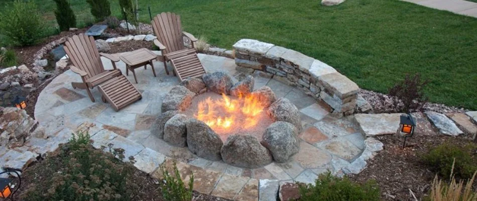 Fire pit on a patio in Prairie City, IA, with a seating wall.