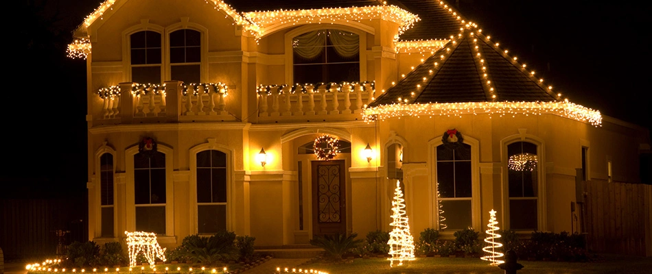 Large home with decorated holiday lights installed in Urbandale, IA.