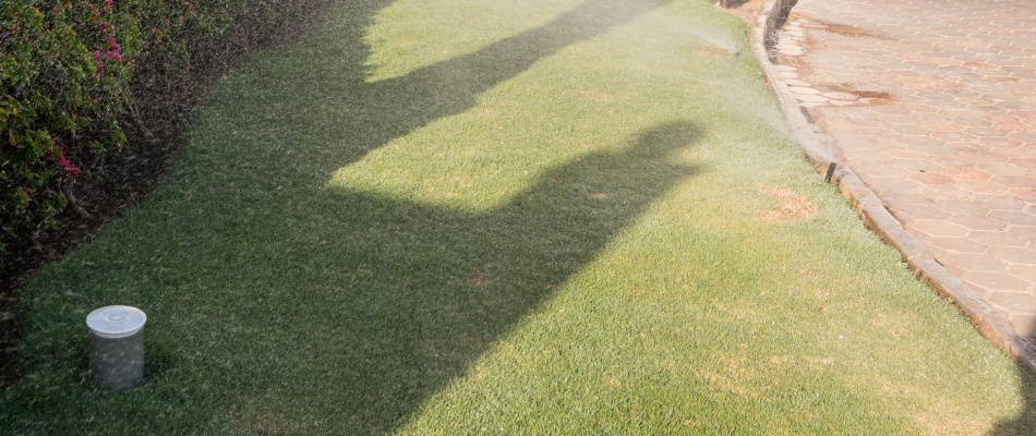 Patchy lawn with irrigation sprinklers in lawn in Des Moines, IA.