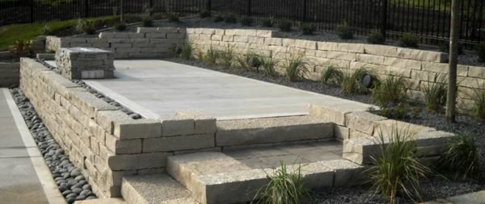 Patio in Runnells, IA, with shrubs and rocks.