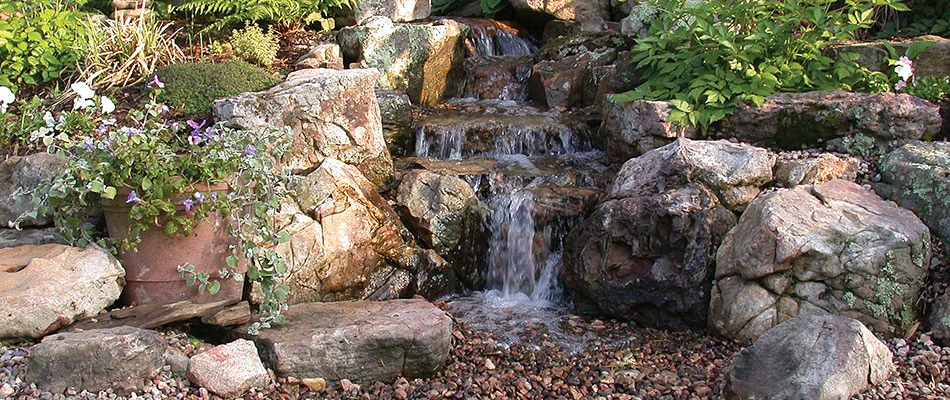 Pondless waterfall surrounded by plantings in Des Moines, IA.