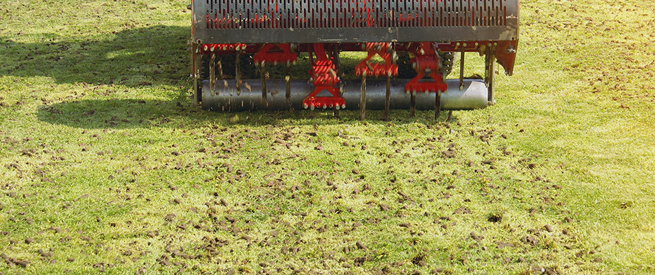A red aeration machine at work on our client's lawn in Urbandale, IA.